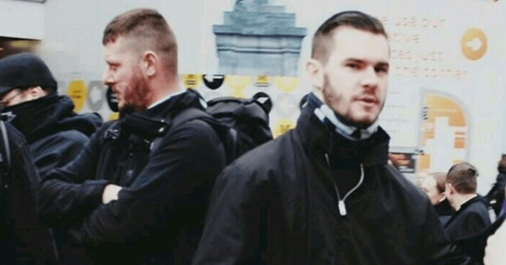 2 members of banned Neo-nazi group national action wearing all black