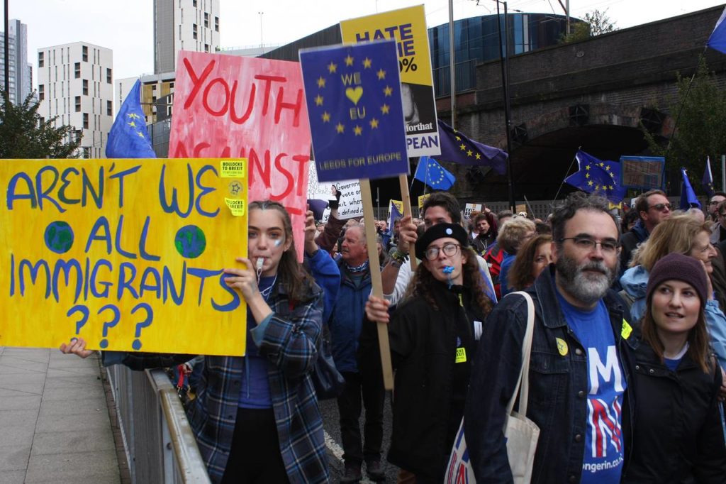 a group of people protesting to stay in the EU. One Placard reads: "Aren't we all immigrants?"