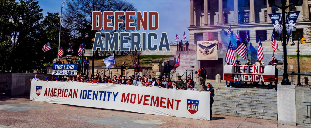 Member of Generation Identity rallying. Banners which reads "American Identity Movement" and "Defend America".