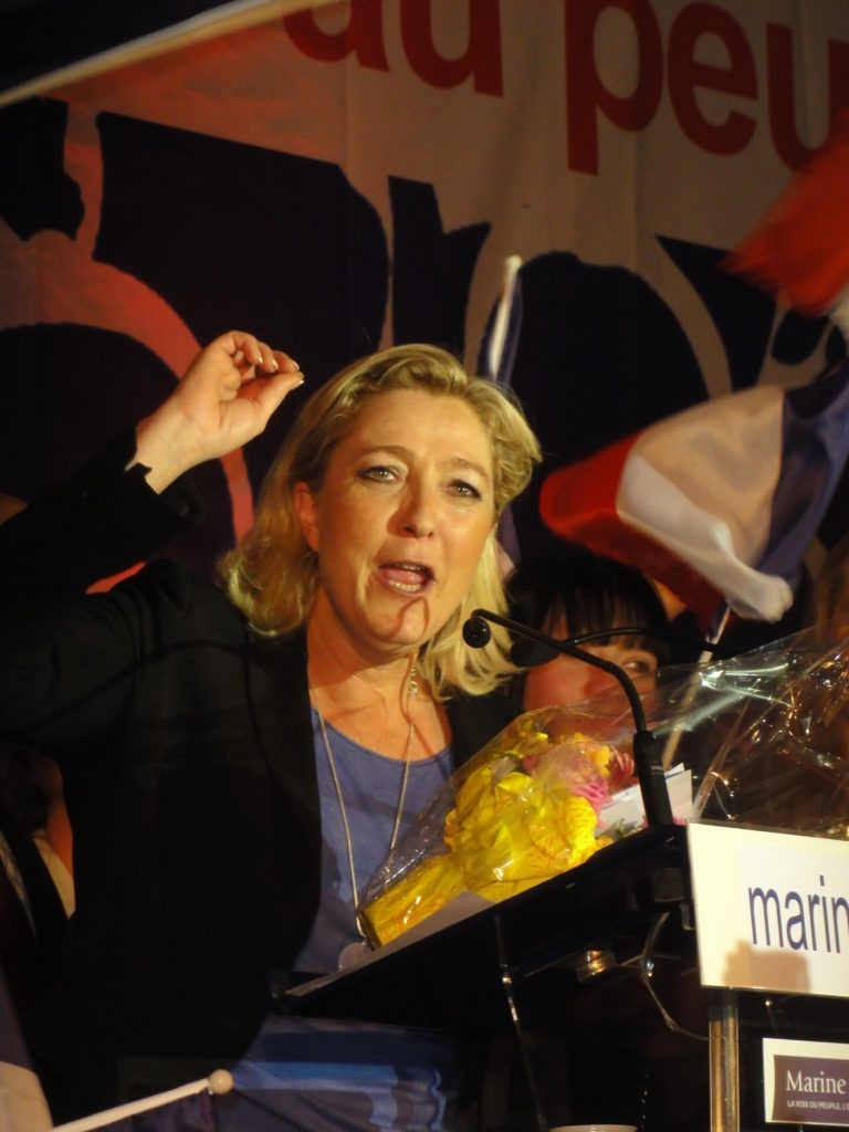 Marine Le Pen behind a podium giving a speech