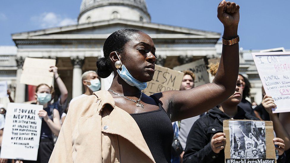 A woman has her fist held up while protesting at the BLM march, London 2020. 