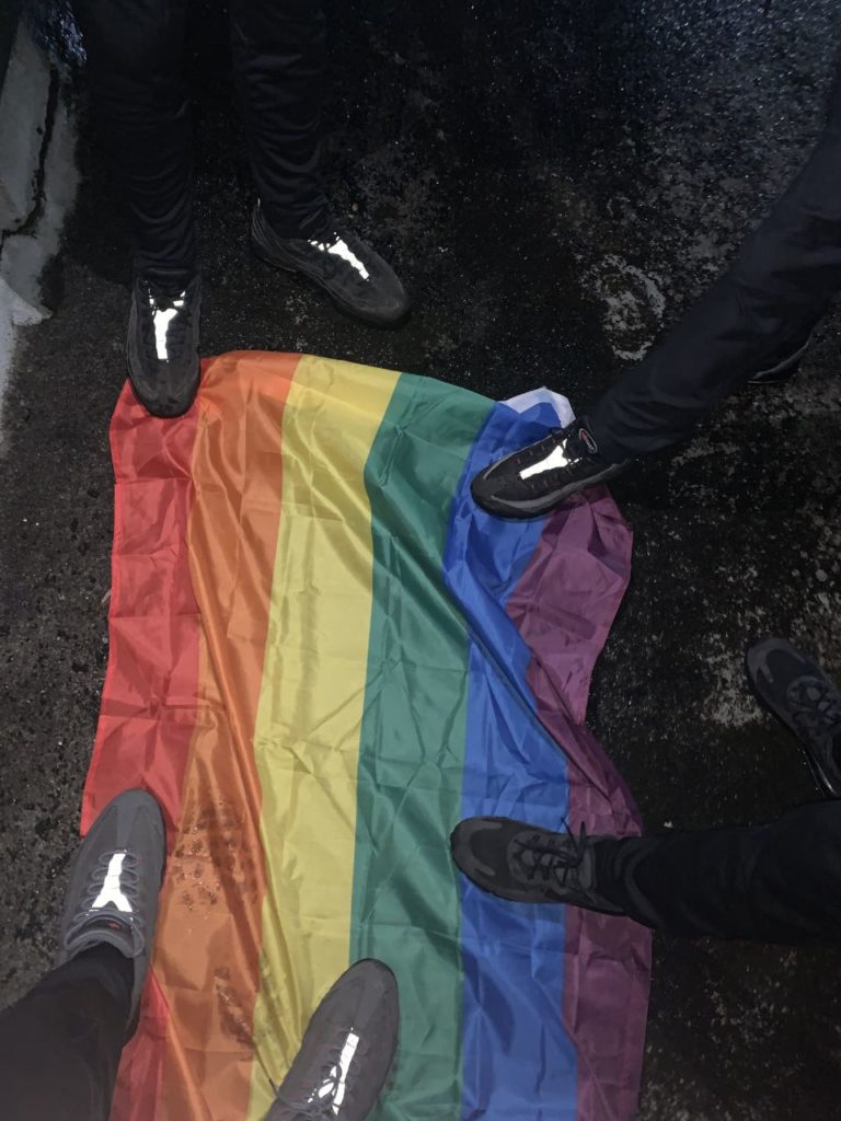 NPM members stamping their feet on the Pride flag